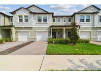 Two story townhome with green exterior and two-car garage at 21811 Lyonia Ln, Land O Lakes, FL 34637