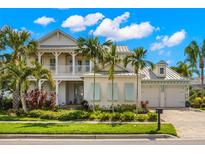 Two-story home with light-colored siding, a metal roof, and a covered porch at 709 Manns Harbor Dr, Apollo Beach, FL 33572
