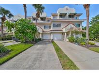 Two story townhome with attached garage and lush landscaping at 4654 Mirabella Ct, St Pete Beach, FL 33706