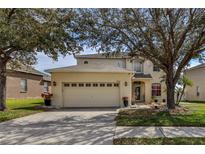 Two story house with a large yard and attached garage at 8556 Southern Charm Cir, Brooksville, FL 34613