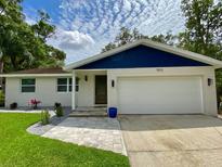 Charming single-story home featuring a well-manicured lawn, brick facade, and attached two car garage at 1503 Edna Ave Nw, Largo, FL 33770