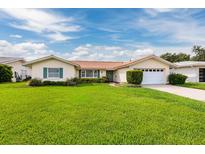 Single-story home with lush lawn, attached garage, and tile roof at 1985 Michigan Ne Ave, St Petersburg, FL 33703