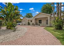 Charming single-story home featuring a beautiful brick driveway and lush tropical landscaping at 1740 51St N St, St Petersburg, FL 33710