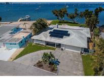 Waterfront property with solar panels, a spacious driveway, and a view of the bay and boats at 4751 Baywood Point S Dr, Gulfport, FL 33711
