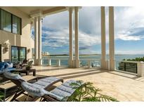 Expansive balcony with stone floors, tall columns, and ocean views provide an elegant outdoor living space at 774 Nina Dr, Tierra Verde, FL 33715