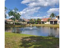 Beautiful view of a pond with fountain and several houses with solar panels in the background at 6816 Dali Ave # 101, Land O Lakes, FL 34637