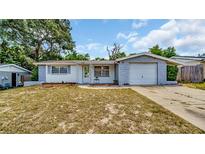 One-story home with gray block exterior and attached garage at 9406 Rainbow Ln, Port Richey, FL 34668
