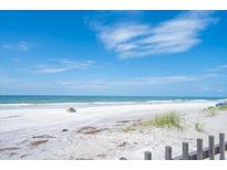 Expansive view of the sandy beach with blue water and clear skies at 14300 Gulf Blvd # 206, Madeira Beach, FL 33708