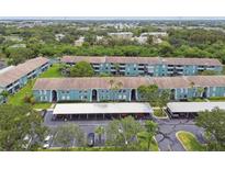 Aerial view of a teal condominium complex with parking and landscaping at 244 115Th N Ave # 3, St Petersburg, FL 33716