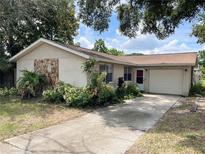 Single-story home with attached garage and landscaped front yard at 1707 Solon Ave, Dunedin, FL 34698