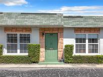 Front view of a single story home with green door and well manicured hedges at 7839 39Th N Ter, St Petersburg, FL 33709