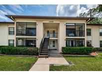 Two-story apartment building with a central staircase and landscaping at 3345 Crystal E Ct # F, Palm Harbor, FL 34685