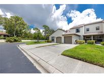 Two-story townhome with double garage and grassy area at 602 Quail Keep Dr, Safety Harbor, FL 34695