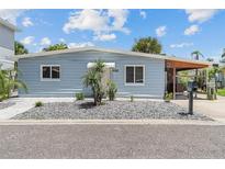 Light blue house with landscaped yard, driveway, and carport at 18053 2Nd E St, Redington Shores, FL 33708