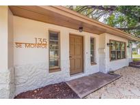 Updated home exterior featuring a charming front entrance and landscaping at 135 Se Monroe N Cir, St Petersburg, FL 33703