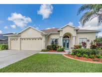 House exterior with three-car garage and manicured landscaping at 22531 Eagles Watch Dr, Land O Lakes, FL 34639