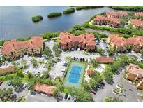 Stunning aerial view of a waterfront condo community featuring a tennis court and lush landscaping at 2732 Via Murano # 526, Clearwater, FL 33764