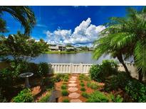 Landscaped backyard with stone path, bird bath, and peaceful lake view at 903 San Carlos Ne Ave, St Petersburg, FL 33702