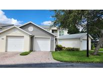 Two-car garage with additional storage space and landscaped yard at 11520 Shipwatch Dr # 1386, Largo, FL 33774