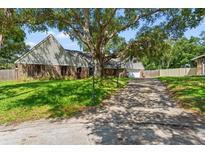 Single-Gathering home with mature landscaping and large oak tree at 1000 Forest Ct, Dunedin, FL 34698