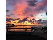 Scenic waterfront view of a sunset from a boardwalk showcasing vibrant colors and tranquil water at 100 Bluff View Dr # 405C, Belleair Bluffs, FL 33770