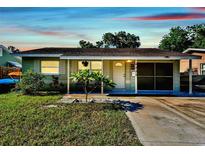 Charming single-story home with well-maintained lawn, mature trees, and private driveway under a colorful sky at 6220 5Th S Ave, St Petersburg, FL 33707