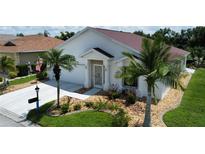 White house with red tile roof, landscaping, and a driveway at 24327 Buckingham Way, Punta Gorda, FL 33980