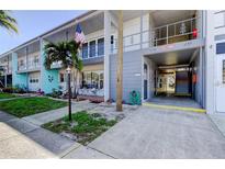 Charming condo building with neat landscaping, sidewalk and an American flag waving at 5820 43Rd N Ter # 1406, St Petersburg, FL 33709