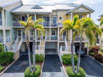 Inviting multi-level condo with palm trees and a metal roof, nestled in a well-maintained community at 603 Bahia Beach Blvd, Ruskin, FL 33570