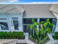 Close aerial view of a condo unit with landscaping featuring palms and other greenery, well maintained complex at 14204 Heritage Landing Blvd # 714, Punta Gorda, FL 33955