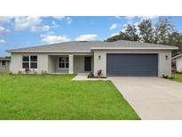 Charming single-story home featuring a well-manicured lawn and a two-car garage at 3067 Newbury St, Port Charlotte, FL 33952