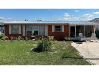 Charming single-story home with an easy-to-maintain lawn, a walkway, and a cozy porch with seating at 29146 Tamayo Dr, Punta Gorda, FL 33982