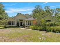 Charming single-story home with a well-manicured lawn and lush landscaping at 11933 Pasco Trails Blvd, Spring Hill, FL 34610