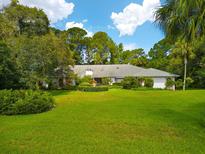 Single-story home with a large green lawn and mature trees at 6049 Patricia Pl, Weeki Wachee, FL 34607