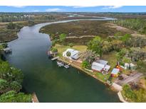 Aerial view of waterfront property with boat and dock at 8064 Marys Fish Camp Rd, Weeki Wachee, FL 34607