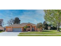 Attractive one-story home with a large, grassy yard and a screened-in porch at 3473 Conifer Loop, Spring Hill, FL 34609