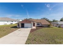 Single story home with attached garage and well-maintained landscaping at 8091 Shalom Dr, Spring Hill, FL 34606