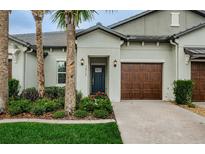 Modern home exterior with a two-car garage at 16715 Shell Bay Dr, Land O Lakes, FL 34638