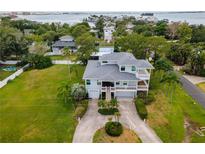 Aerial view of a waterfront home with a large yard and driveway at 329 Sunset Way, Palm Harbor, FL 34683