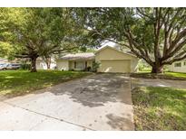 Single story home with driveway and mature landscaping at 12709 Clock Tower Pkwy, Hudson, FL 34667