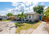 Gray duplex with teal accents, landscaped yards, and a spacious driveway at 6805 Gulf Winds Dr, St Pete Beach, FL 33706