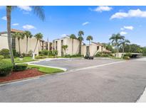 Condo building with parking and tropical landscaping at 2207 Belleair Rd # A32, Clearwater, FL 33764