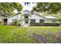 White single-story house with well-manicured lawn and landscaping at 2727 Featherstone Dr # 2727, Holiday, FL 34691