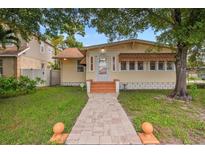 Charming single-story home with a brick walkway, landscaped front yard and mature trees at 1501 28Th N Ave, St Petersburg, FL 33704