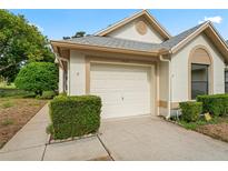 White house with gray roof, attached garage, and well-manicured landscaping at 9108 Bassett Ln # B, New Port Richey, FL 34655