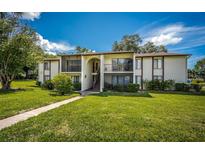 Two-story condo building with balconies and lush landscaping at 2522 Pine Ridge S Way # A2, Palm Harbor, FL 34684
