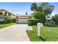 Ranch style home with a two-car garage and a neat lawn at 6316 Spoonbill Dr, New Port Richey, FL 34652