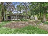 Single-wide mobile home with covered porch and a large yard at 9520 Merton St, New Port Richey, FL 34654