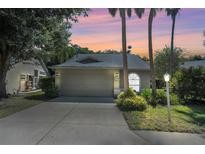 Tan one-story house with a two-car garage, at dusk at 7817 Geneva Ln, Sarasota, FL 34243