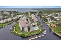 Waterfront condo community featuring boat docks, swimming pool, lush landscaping, and water views at 8210 Aquila St # 227, Port Richey, FL 34668